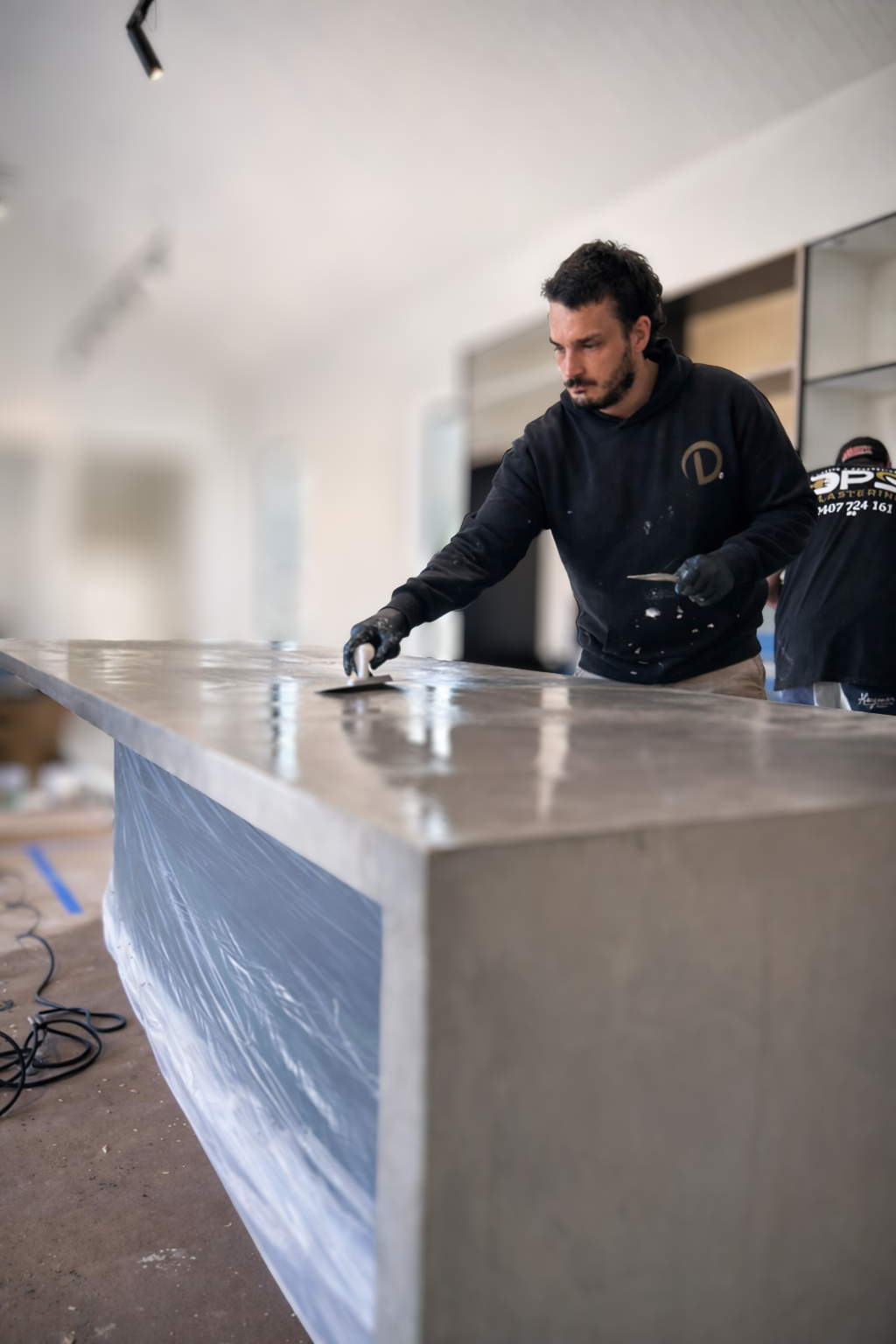 Lux Cement founder hand-applying microcement to a kitchen benchtop